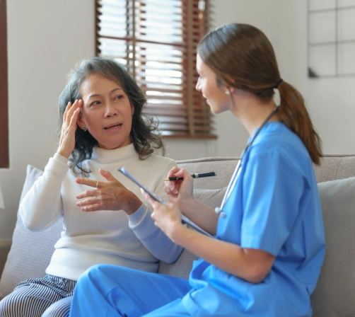 A female caregiver talking to a senior woman