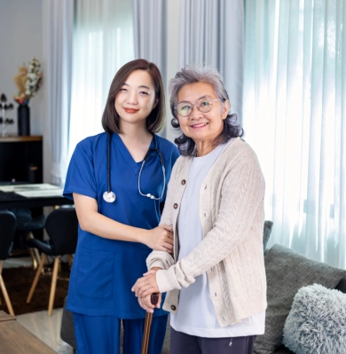 A female caregiver and a senior woman smiling